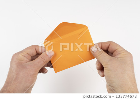 an open orange envelope in the hands an open orange envelope in the hands 135774678