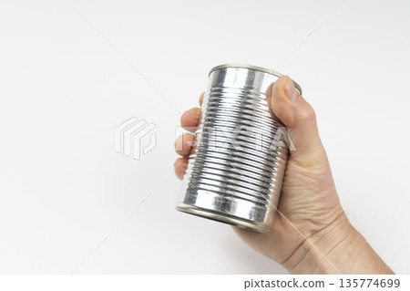 a can of food in the hand 135774699