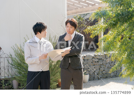 Men having a meeting outside their home Men having a meeting outside their home 135774899