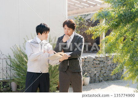 Men having a meeting outside their home 135774900