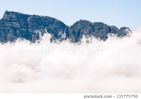 Table Mountain emerging from thick cloud above Cape Town, South Africa. Aerial view from helicopter tour for travel and vacation. 135775750