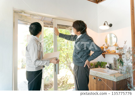 幾個穿著工作服的男人在玻璃門前開會。 135775776