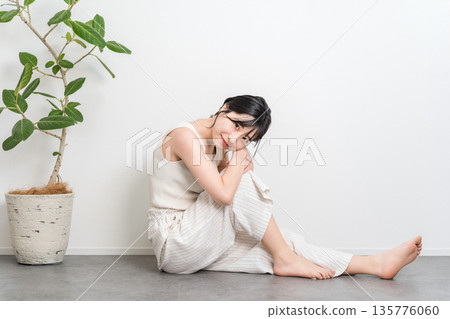A beautiful Asian woman with a smile sitting on the floor (beauty, diet, hair removal) 135776060