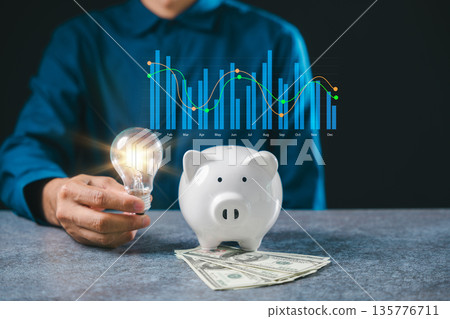 Knowledge fuels financial innovation using glowing lightbulb held by hand beside piggy bank with money, business concept utilizes knowledge for investment strategy digital research 135776711