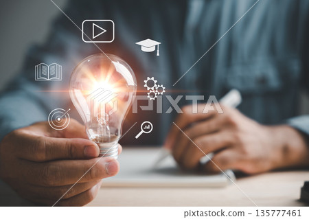 To learn new skills, see how a hand holds a lightbulb illuminating e-learning icons, a creative course where you can also learn about internet education degree goal setting and study knowledge To learn new skills, see how a hand holds a lightbulb illuminating e-learning icons, a creative course where you can also learn about internet education degree goal setting and study knowledge 135777461