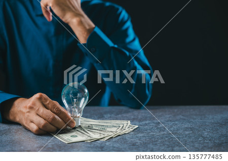 Businessman holding light bulb idea shows business innovation solution, marketing growth concept while contemplating knowledge management, leadership global market success 135777485