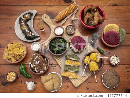 mixed colombian and venezuelan food meal spread on wooden restaurant table mixed colombian and venezuelan food meal spread on wooden restaurant table 135777744