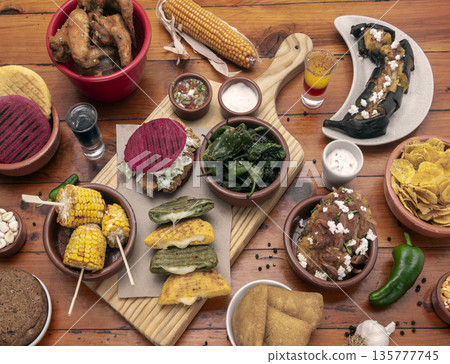 mixed colombian and venezuelan food meal spread on wooden restaurant table 135777745