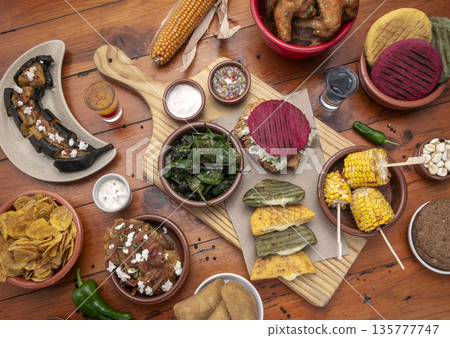 mixed colombian and venezuelan food meal spread on wooden restaurant table mixed colombian and venezuelan food meal spread on wooden restaurant table 135777747