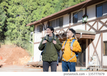 Image of a tourist climbing a mountain in autumn and winter, profile view, aiming to reach the summit Image of a tourist climbing a mountain in autumn and winter, profile view, aiming to reach the summit 135777879