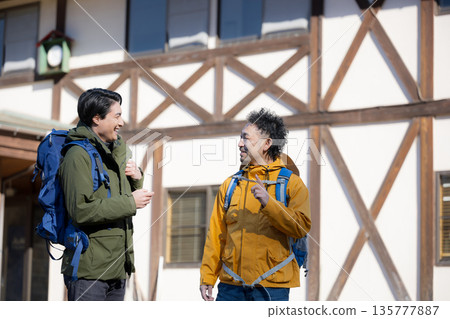 Autumn winter fun image of tourists climbing mountain from mountain hut Autumn winter fun image of tourists climbing mountain from mountain hut 135777887