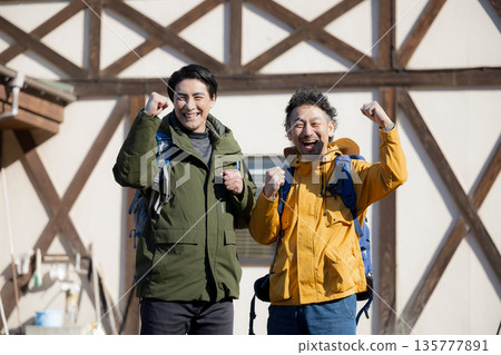 Fun image of tourists climbing mountains from mountain hut, fist pump 135777891
