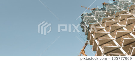 Construction of a building banner background. Construction site with crane. Business, development, industry. Construction of a building banner background. Construction site with crane. Business, development, industry. 135777969