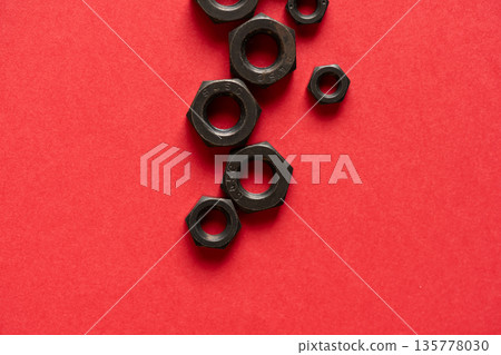 紅色背景中的六角螺栓螺母 紅色背景中的六角螺栓螺母 135778030