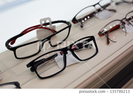Shelf with prescription glasses. Selection of different glasses for vision correction. Glasses that help improve vision are displayed on shelf. Large selection of glasses in various designs Shelf with prescription glasses. Selection of different glasses for vision correction. Glasses that help improve vision are displayed on shelf. Large selection of glasses in various designs 135780213