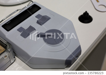 Testing equipment on ophthalmologist desk. Vision testing with device. Concept of modern technologies in medicine. Eyes testing and glasses selection with device. Ophthalmologist tool 135780223