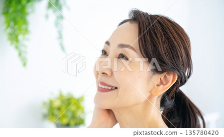 一幅笑容燦爛、肌膚姣好的中年女性肖像，靈感來自廣告 135780420