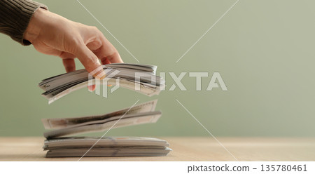 Hand releasing bundles banknotes falling onto stack. Concept of spending, cash flow Hand releasing bundles banknotes falling onto stack. Concept of spending, cash flow 135780461
