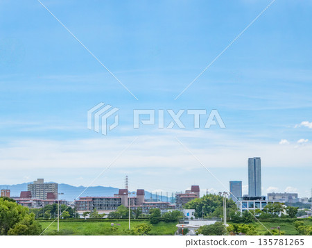 Suburban cityscape with mountains in the distance and expansive blue skies 135781265