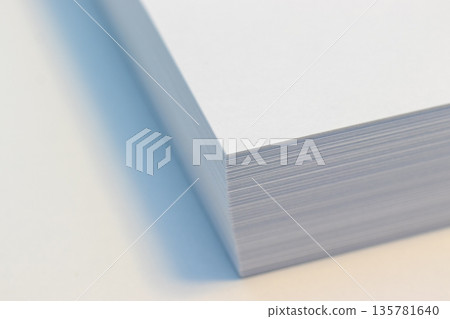 Stacks of white paper on a desk 135781640