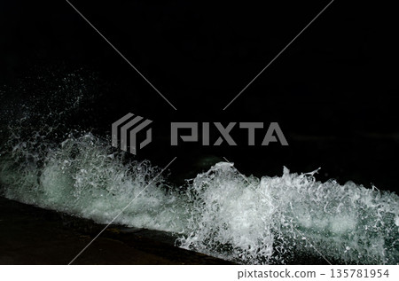 Nighttime water burst, splashing white foam Nighttime water burst, splashing white foam 135781954