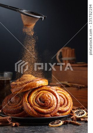 Kanelbullar. Freshly baked buns sprinkled with cinnamon. 135782194