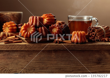 Cinnamon cakes and tea on an old wooden table. Cinnamon cakes and tea on an old wooden table. 135782217