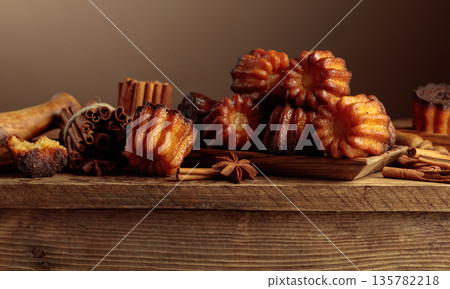 Cinnamon cakes with ingredients on an old wooden table. Cinnamon cakes with ingredients on an old wooden table. 135782218
