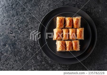 Baklava with walnuts on a blackstone table. Baklava with walnuts on a blackstone table. 135782228