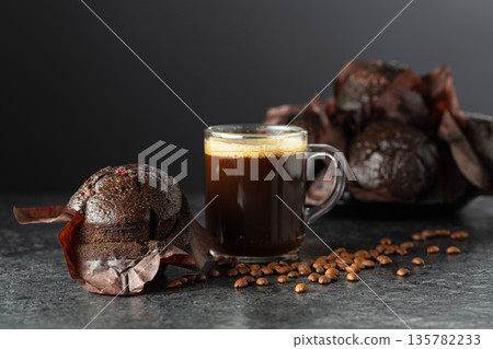 Dark chocolate muffins and cup of black coffee. Dark chocolate muffins and cup of black coffee. 135782233