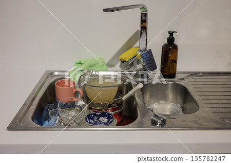 Dirty dishes in sink on the kitchen Dirty dishes in sink on the kitchen 135782247