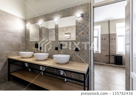 Modern hostel bathroom with vessel sinks and industrial loft design 135782438