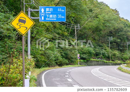 Slip warning sign on Prefectural National Route 142 and a sign to Suwa and Shimo-Suwa (mountain road scenery) Slip warning sign on Prefectural National Route 142 and a sign to Suwa and Shimo-Suwa (mountain road scenery) 135782609