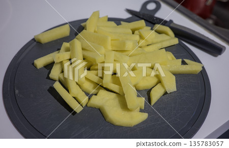 Sliced potatoes on a grey plastic tray Sliced potatoes on a grey plastic tray 135783057
