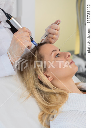 Woman scalp microneedling and injection treatment for hair growth stimulation in trichology clinic 135783422