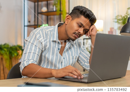 Indian man closes laptop with swift hand mutters enough leans back exhales and takes screen-break 135783492