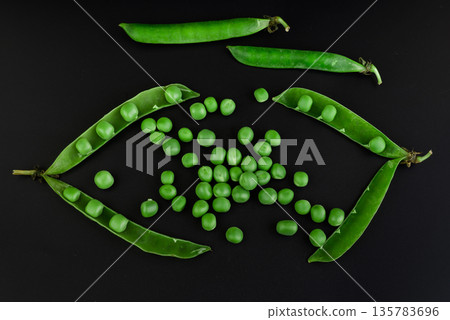 Peas in pods and green grains, on a black background isolated Peas in pods and green grains, on a black background isolated 135783696