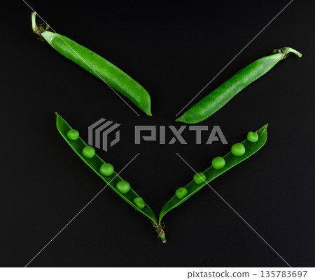 Two whole peas and one open stitch of peas with grains on a black background 135783697