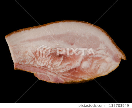 A thick piece of ready-made appetizing, smoked, lard with layers of meat on a black background in isolation 135783949