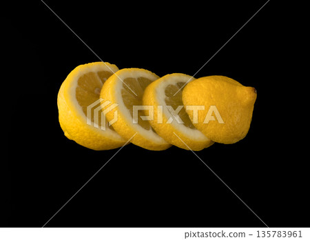 Lemon sliced in round slices on black background isolated Lemon sliced in round slices on black background isolated 135783961