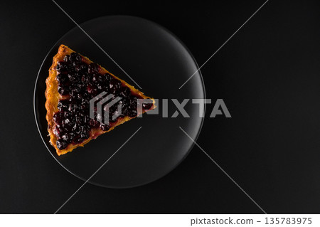 Piece of pie with carrots and currants sprinkled on top on black background f isolation Piece of pie with carrots and currants sprinkled on top on black background f isolation 135783975