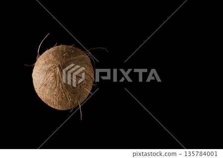 One whole ripe coconut, on black background, isolated One whole ripe coconut, on black background, isolated 135784001