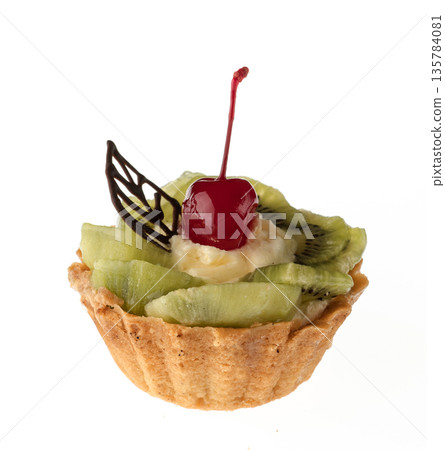 Dessert, cake with kiwi and cherries, on a white plate isolated 135784081