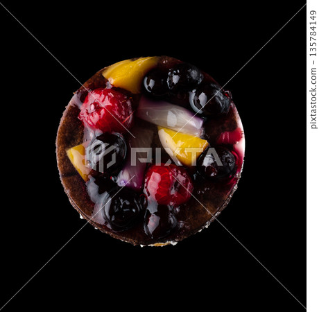 Pastry stuffed with fruits, berries and citrus fruits on a black background in isolation, view from the top, confectionery product Pastry stuffed with fruits, berries and citrus fruits on a black background in isolation, view from the top, confectionery product 135784149