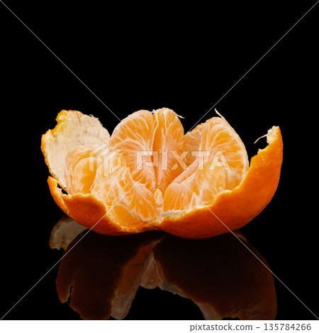 Ripe tangerine, half peeled against a black background with reflection 135784266