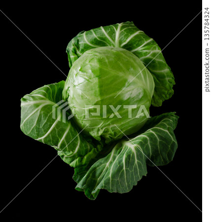 Head of green young fresh cabbage with loose leaves, on black background 135784324
