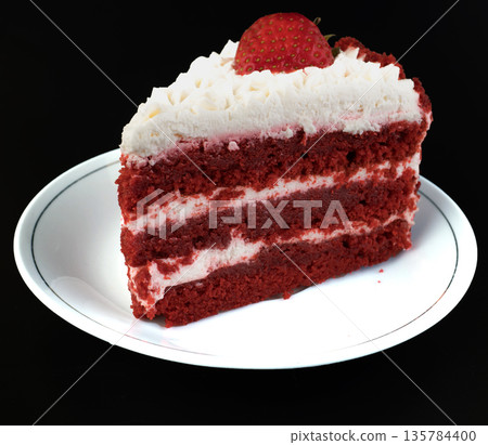 A piece of cake with protein cream, in a white plate on a black background A piece of cake with protein cream, in a white plate on a black background 135784400