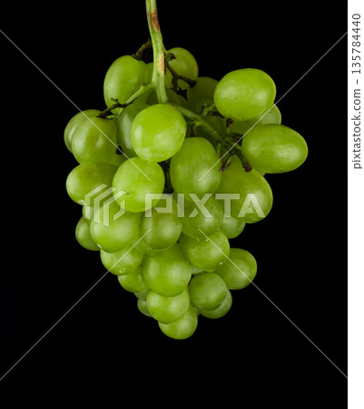 A bunch of grapes, white filling, with large sponges, on a black background in isolation A bunch of grapes, white filling, with large sponges, on a black background in isolation 135784440
