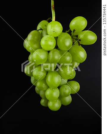 A bunch of grapes, white filling, with large sponges, on a black background A bunch of grapes, white filling, with large sponges, on a black background 135784441