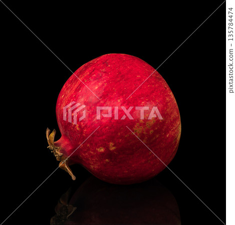 ripe whole pomegranate, on a black background isolated, with reflection ripe whole pomegranate, on a black background isolated, with reflection 135784474